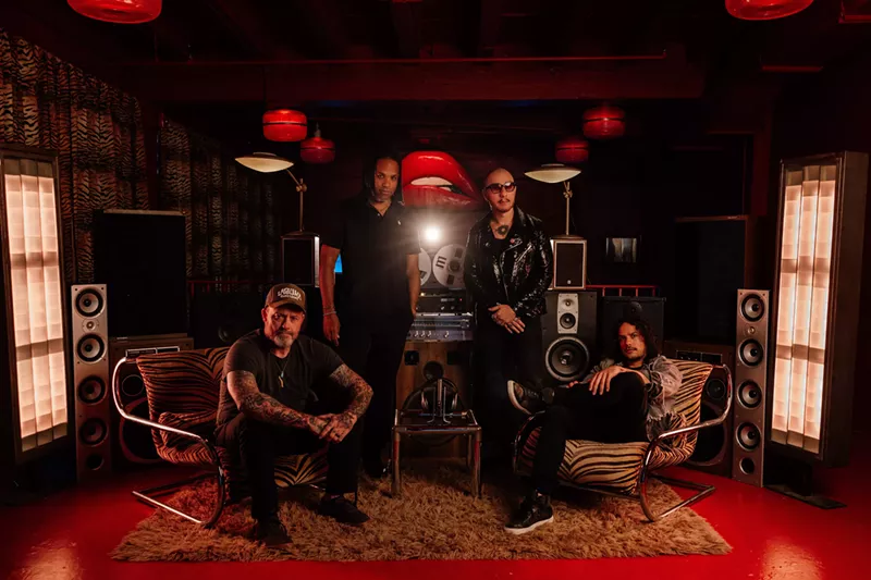 Image: Band in a rehearsal studio posing for the camera.