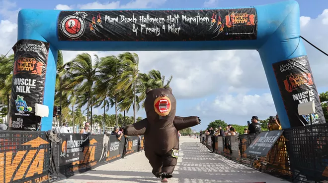 A person in a bear costume crossing the finish line