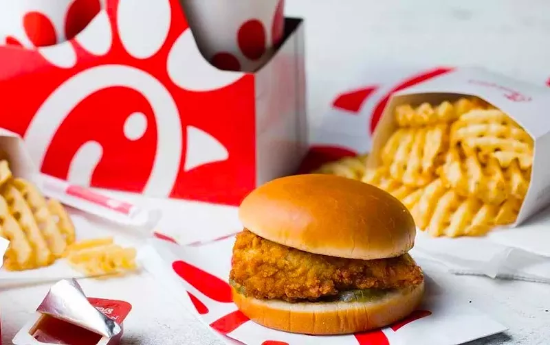 Image: a fried chicken sandwich next to a cup of soda