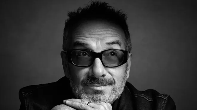 A black and white picture of Elvis Costello posing