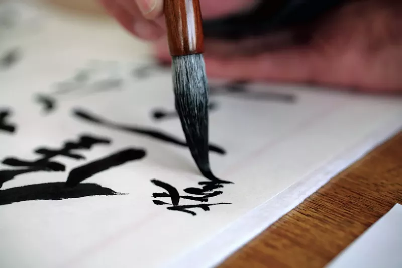 Image: Man doing Japanese calligraphy with a brush