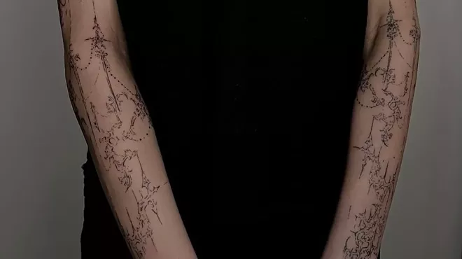 Arms tattooed with a cybersigilism design