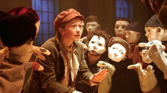 Hallie Walker on stage as Oliver singing with Fagin's boys