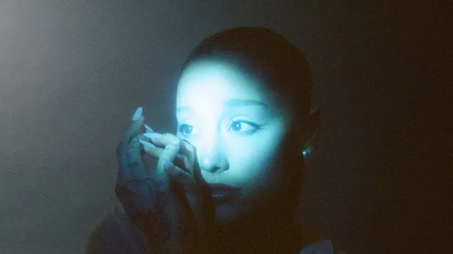Picture of Ariana Grande under a green light.