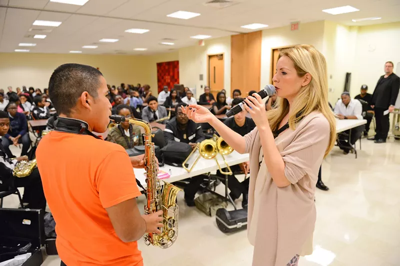 Image: Student Alejandro Cruz plays a note for saxophonist Candy Dulfer during a Jazz Roots Q&A session.