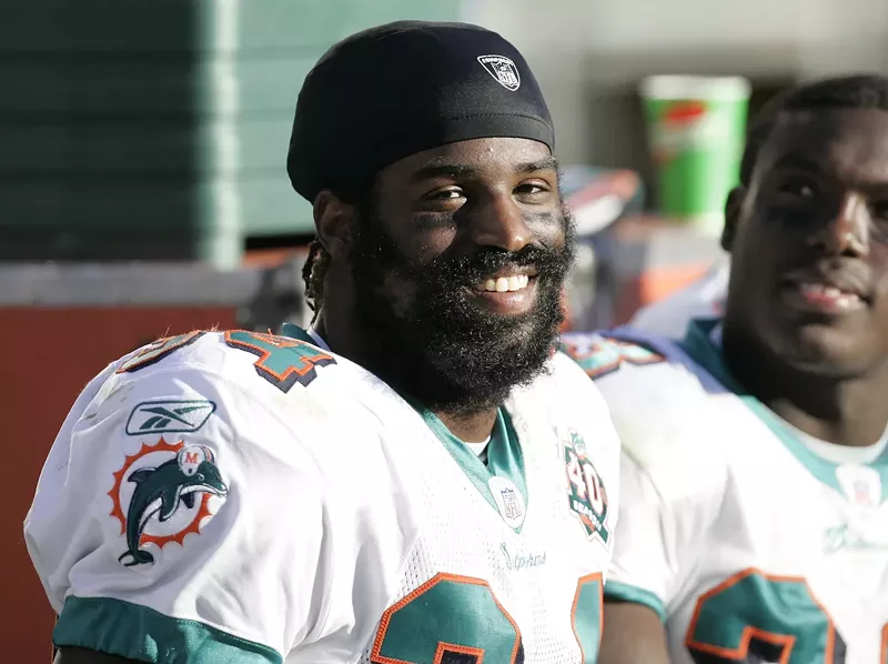 Image: Miami Dolphins running back Ricky Williams smiles on the sidelines as the Miami Dolphins defeat the Oakland Raiders 33–21 at McAfee Coliseum, Oakland, California, November 27, 2005
