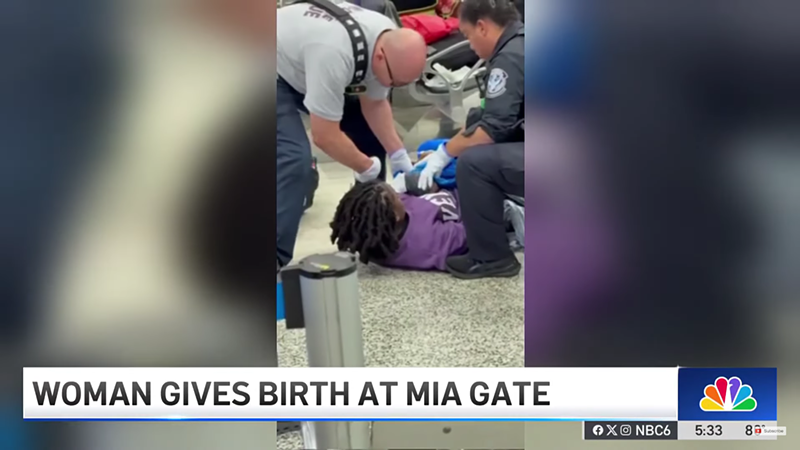 Image: First responders assist a woman lying on the floor of Miami International Airport as she gives birth near Door 3.