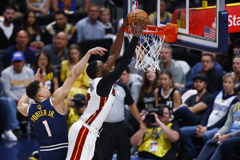 Miami Heat's Bam Adebayo pushes past the Denver Nuggets' Michael Porter Jr. for a slam dunk.