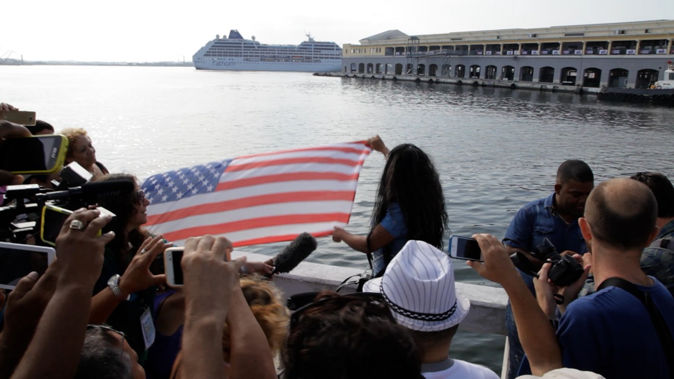Cubans wave a U.S. flag to celebrate the arrival of U.S.-based cruise ships to Cuba in May 2016 during Obama’s rapprochement with the island.
