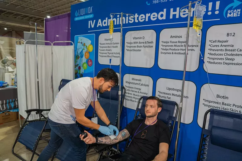 Image: a man administers IV treatment to another man