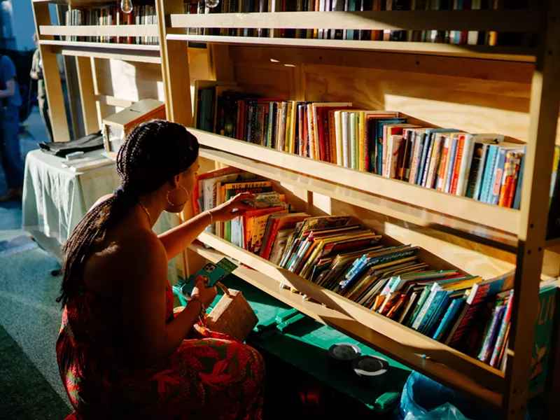 Image: A woman browsing the shelves of the Bookleggers book trailer