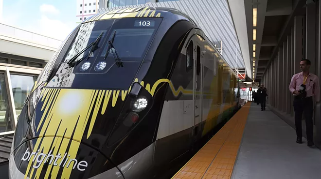 A yellow and black Brightline train sits at the Miami Central terminal.