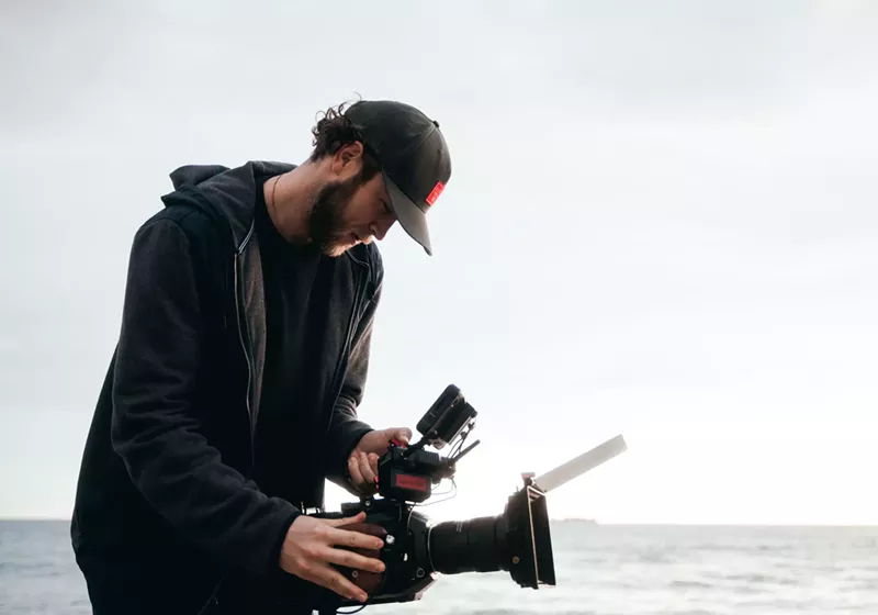 Image: Man filming by the ocean.