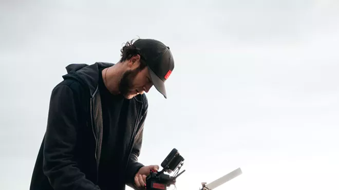 Man filming by the ocean.