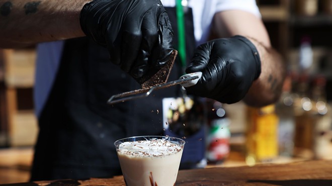 Hands shaving chocolate on drink
