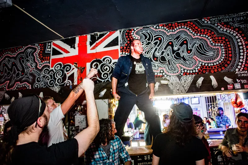 Image: Picture of a band on stage with blood on their faces.