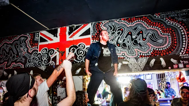Picture of a band on stage with blood on their faces.