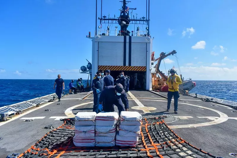 Image: Coast Guard crew members transport confiscated narcotics to an onboard storage location on November 11, 2022.