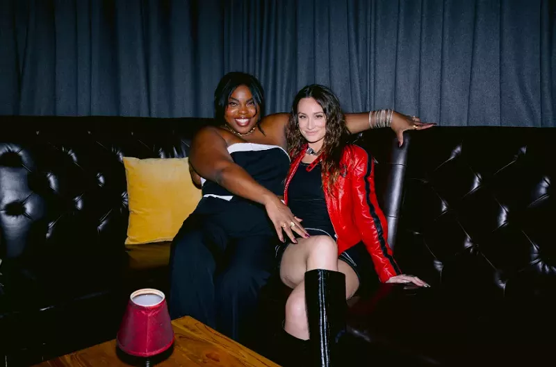 Image: Karolena Theresa and Melissa Rich sitting on a couch