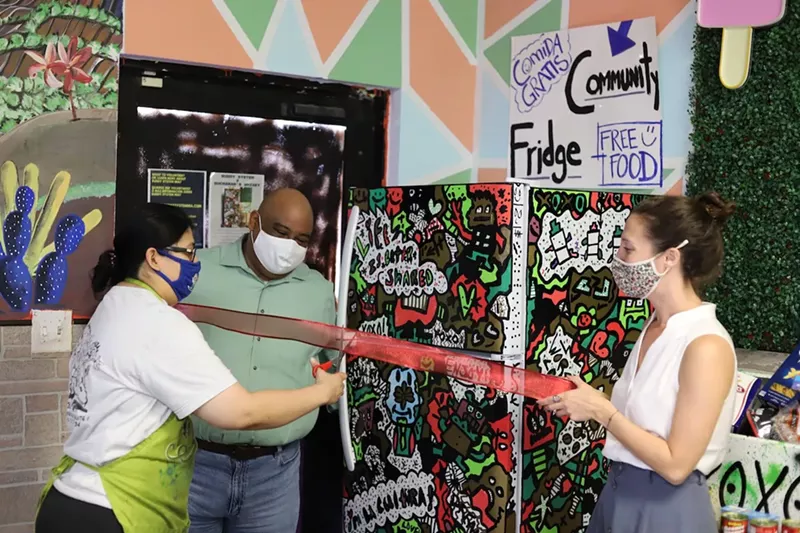 Image: Buddy System activists Diana Resendiz, Gilberto Zepeda, and Kristin Guerin unveil a community fridge in Homestead.
