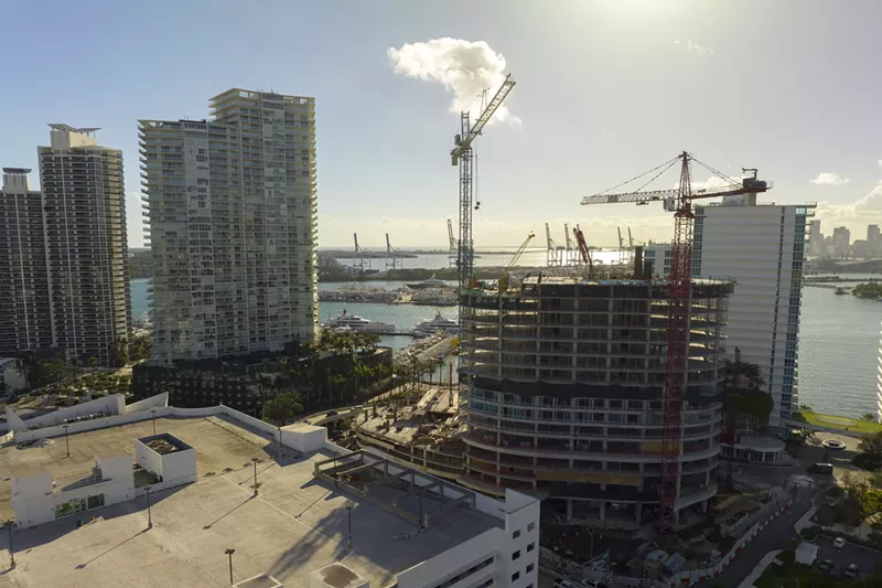 Image: Panoramic view of a skyline with a building site and cranes in the forefront