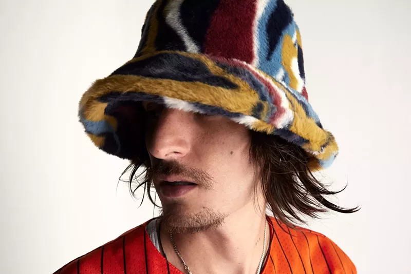 Image: Danny Ocean wearing a bucket hat and orange shirt