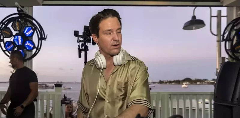 Image: Ron DeSantis face on Kygo's body as he performs at Palm Tree Club. He is wearing a Silk Prada shirt.