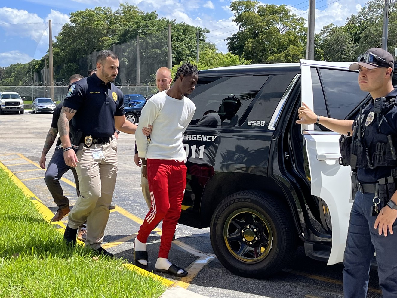 Lionel JeanCharles Jr. is escorted in handcuffs to a police car outside the Hollywood Police Department on June 5, 2023.