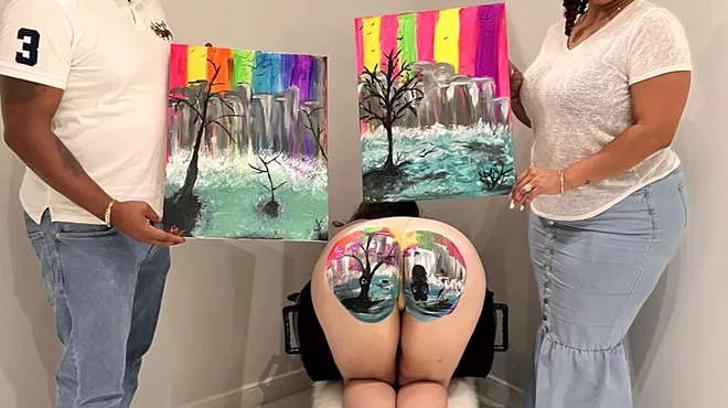 two people hold canvases depicting landscapes on either side of a model's butt depicting a similar landscape