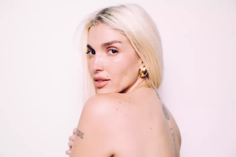 Image: Portrait of a blonde woman with tattoos.