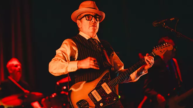 Elvis Costello playing his guitar at a live show