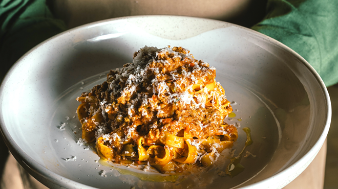 a meat pasta with cheese shavings