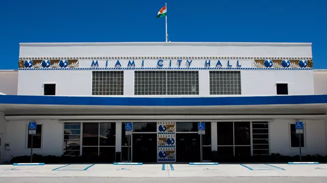 Depicted is Miami City Hall, a white and blue building, on a sunny day.