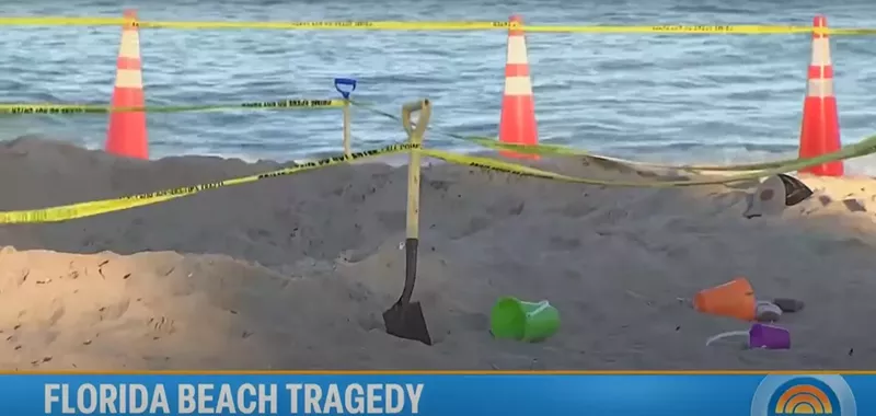 Image: Beach toys, a shovel, and a cone sit on the beach at the site of a fatal sand collapse