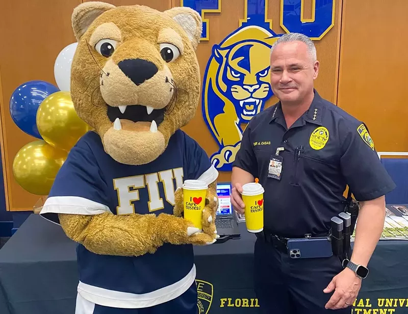 Image: photo of uniformed campus police chief posing with FIU panther mascot. Both are holding large branded Cafe Bustelo disposable coffee cups.