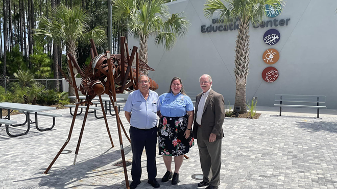 Richard Weaver from the Anastasia Mosquito Control District and two other people stand in front of the Disease Vector Education Center and Science Museum in St. Augustine.