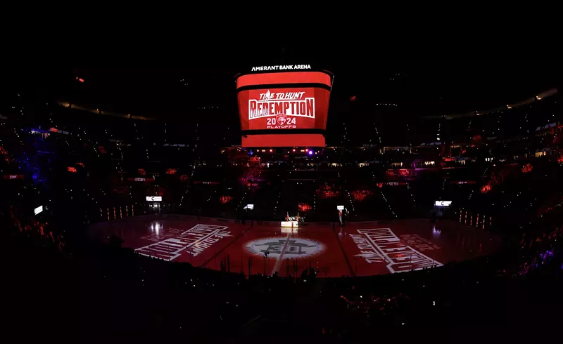 Image: a darkened Amerant Bank Arena with "Redemption" illuminated in white on red on the ice and on the overhead scoreboard