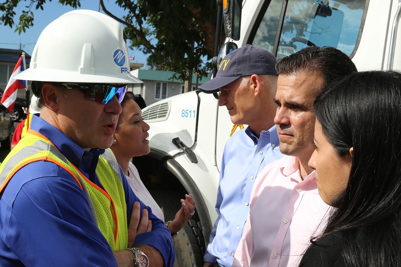 FPL CEO Eric Silagy (left) speaks with Gov. Ricardo Rossello, governor of Puerto Rico, in Bayamon, Puerto Rico, as power was being restored to a neighborhood in February 2018, five months after Hurricane Irma struck the area.