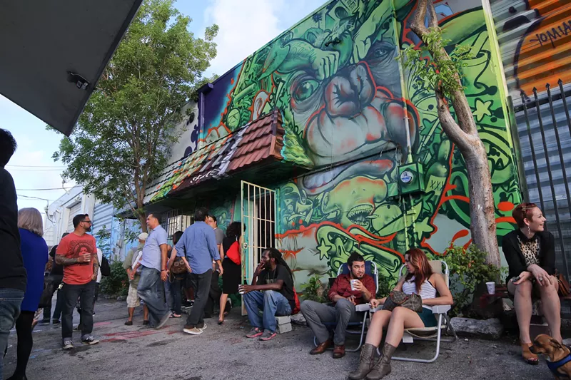 Image: people sit and socialize outside a muralled building