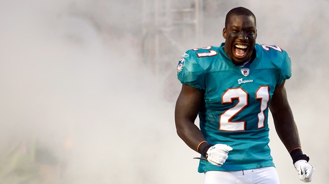 color photo of Miami Dolphins cornerback Vontae Davis grinning from ear to ear as he trots onto the field surrounded by "smoke" during player introductions on September 12, 2011