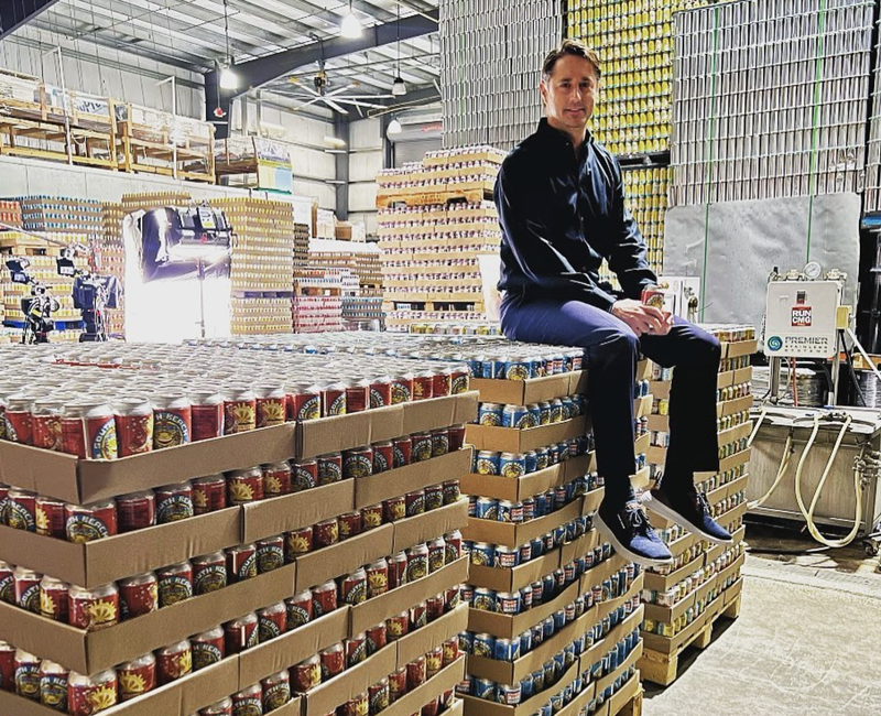 Image: A man sits on cans of beer