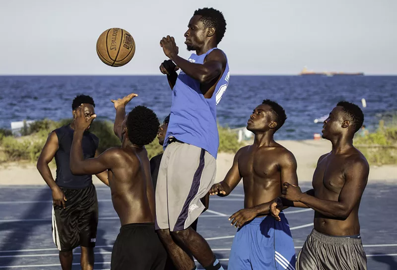 Image: Depicted are men playing basketball at a popular beachside court in Fort Lauderdale.