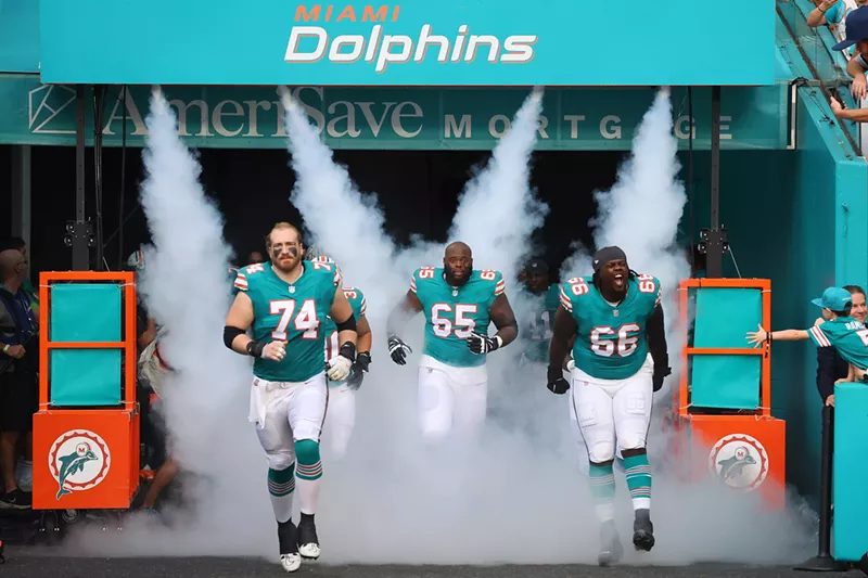 Image: The Miami Dolphins trot onto their home field in Miami Gardens before a game