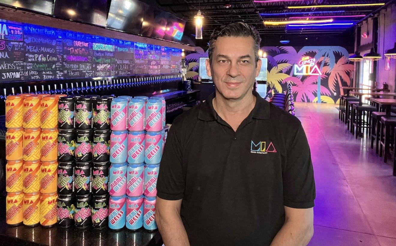 M.I.A. Beer Company founder and managing partner Eddie Leon stands in the brewery's Doral taproom alongside cans of his top-selling beers.