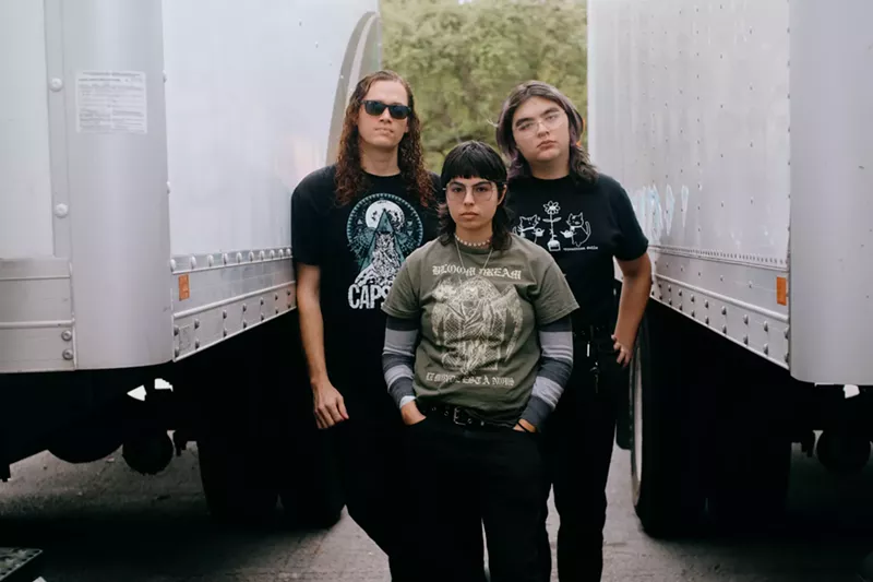 Image: three band members standing next to one another
