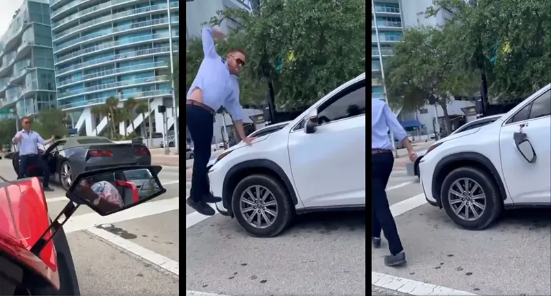 Image: An enraged man leaps into the air in downtown traffic to deliver a hammer fist to an SUV's driver-side mirror