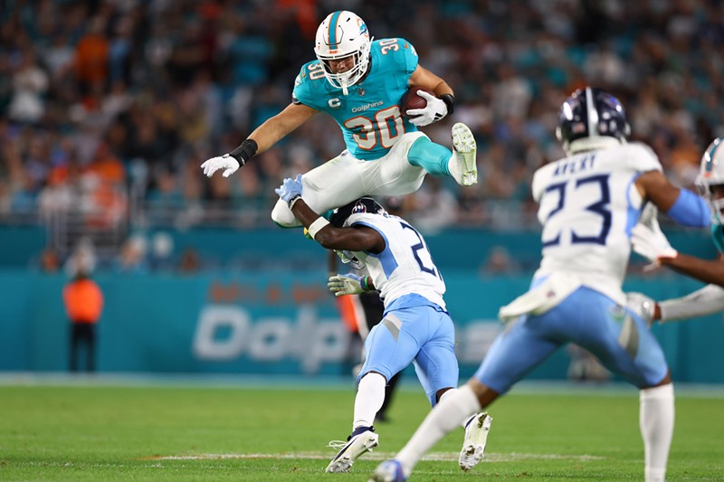 Alec Ingold of the Miami Dolphins hurdles over Roger McCreary of the Tennessee Titans at Hard Rock Stadium on December 11, 2023. Ingold was featured on the fourth episode of HBO's Hard Knocks series.