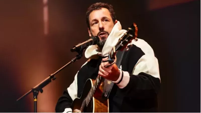 Image: comedian Adam Sandler plays guitar onstage