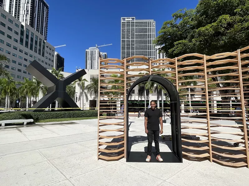 Image: Germaine Barnes standing in front of his outdoor art installation, Ukhamba
