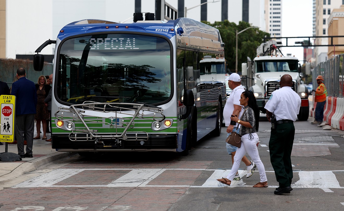 Pedestrians walk past an electric bus on February 02, 2023 in Miami, Florida.